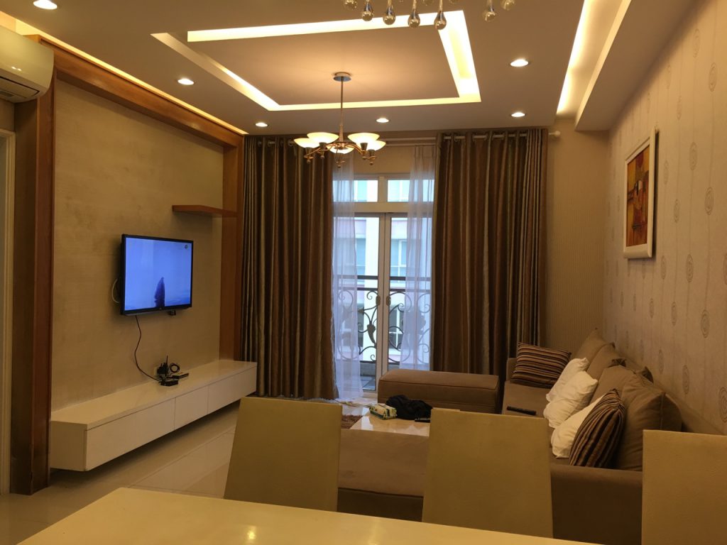 Phòng khách căn hộ Flemington Quận 11 2PN sofa nâu TV tủ trang trí