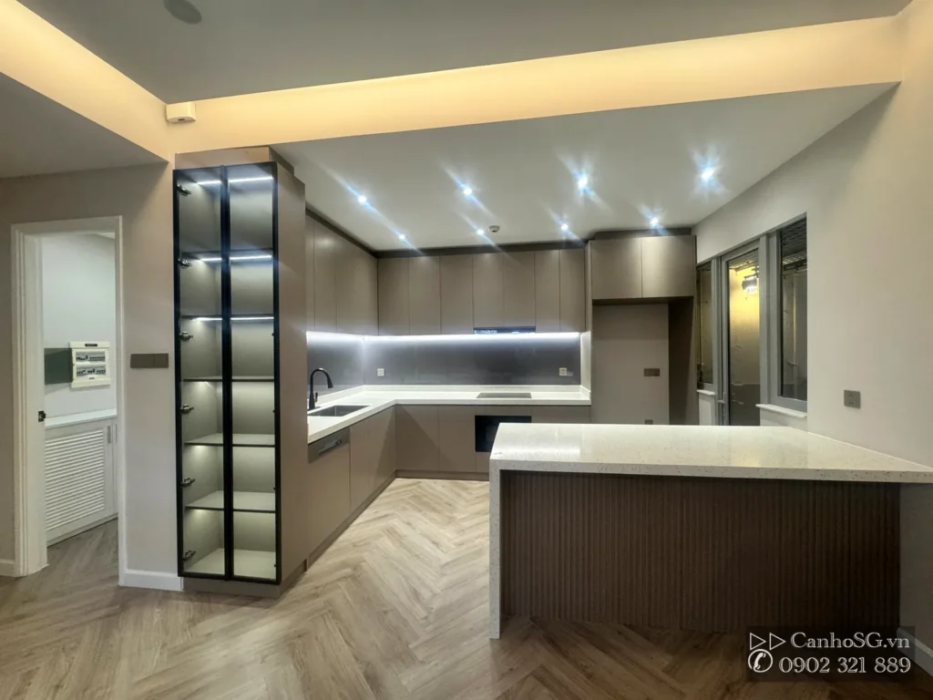 Khu bếp chữ L có đảo bếp, tủ bếp và hệ đèn âm trần Saigon Pearl