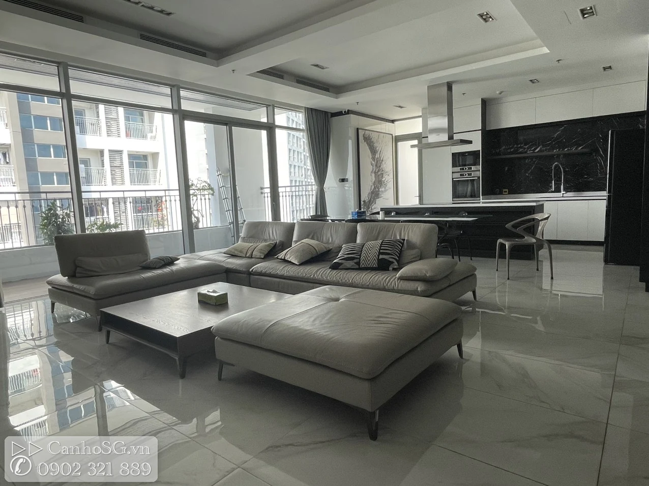 Phòng khách rộng liên thông khu bếp của căn hộ cao cấp, nội thất hiện đại, cửa kính lớn đón sáng tự nhiên