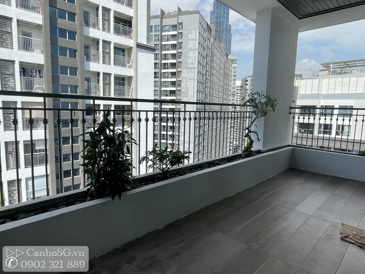 Ban công rộng của căn hộ cao cấp với bồn cây dài, view thoáng nhìn ra các tòa nhà xung quanh