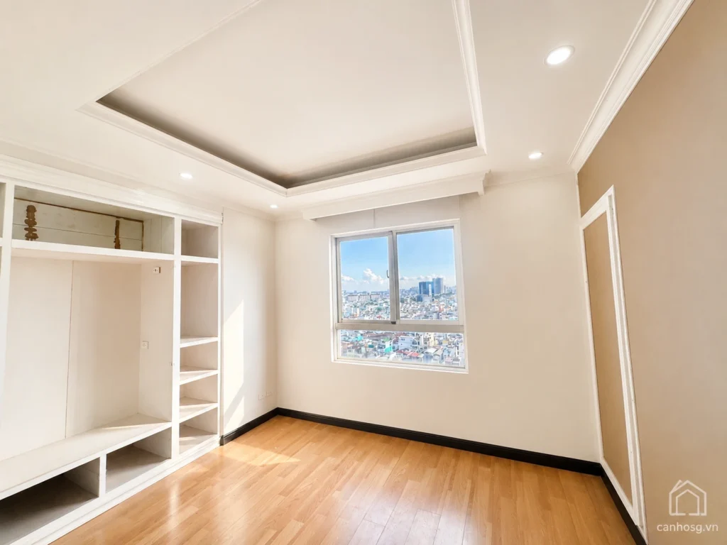 Phòng ngủ căn hộ The Flemington 96m² có sàn gỗ, tủ âm tường và cửa sổ nhìn ra thành phố.