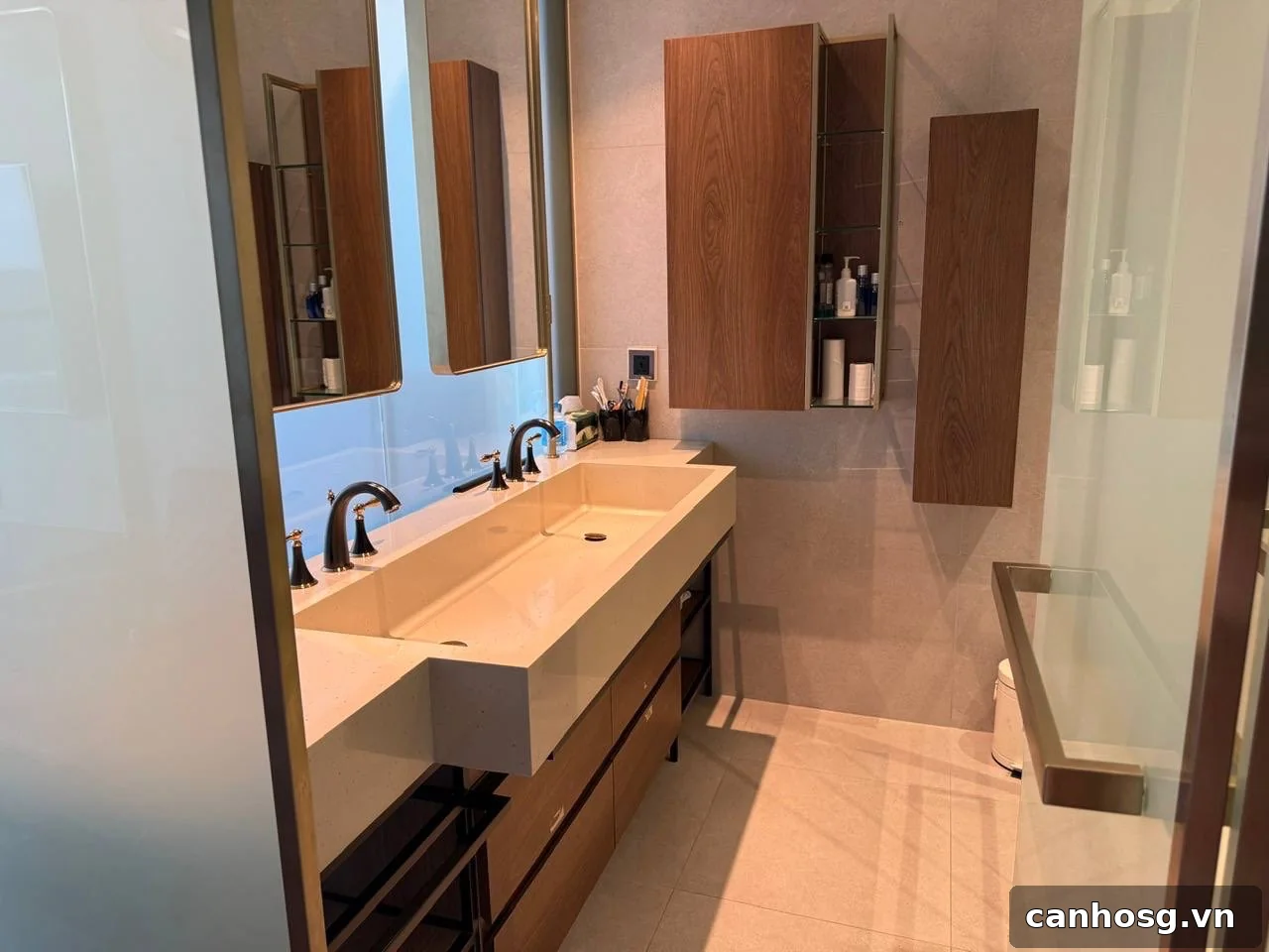 Phòng tắm Penthouse Vinhomes Golden River với lavabo đôi, tủ gỗ và gương lớn