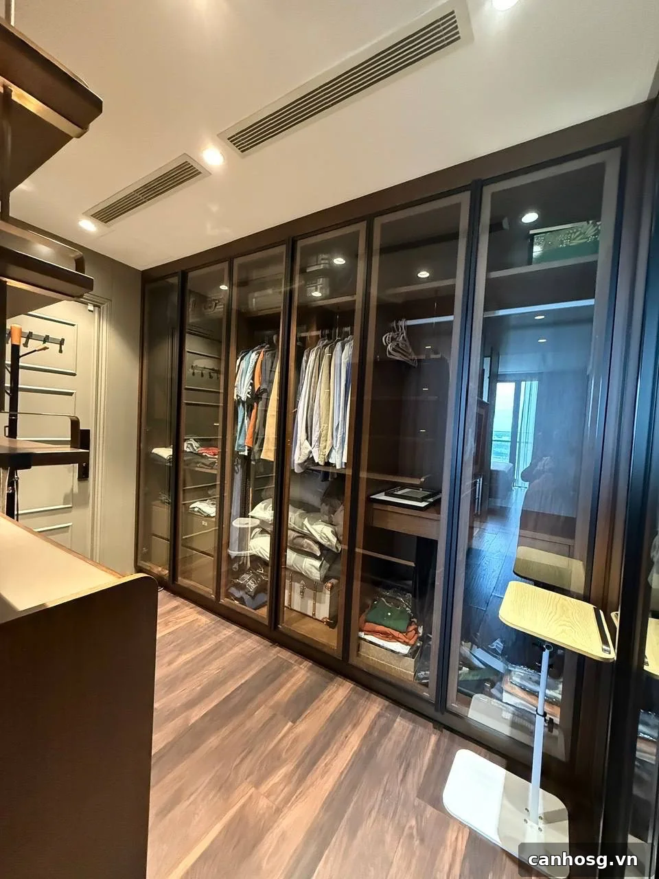 Walk-in closet Penthouse Vinhomes Golden River với hệ tủ kính và không gian thay đồ riêng