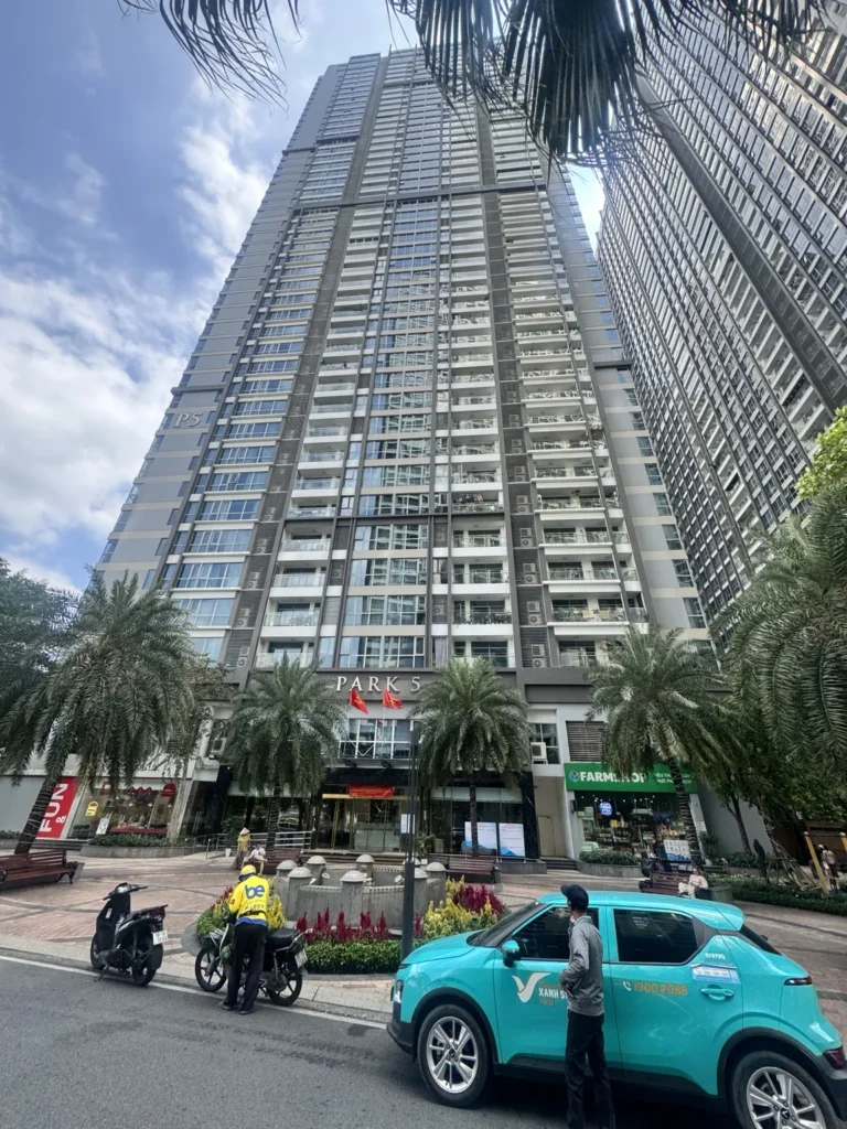 Tòa Park 5 Vinhomes Central Park nhìn từ mặt đường với hàng cây phía trước