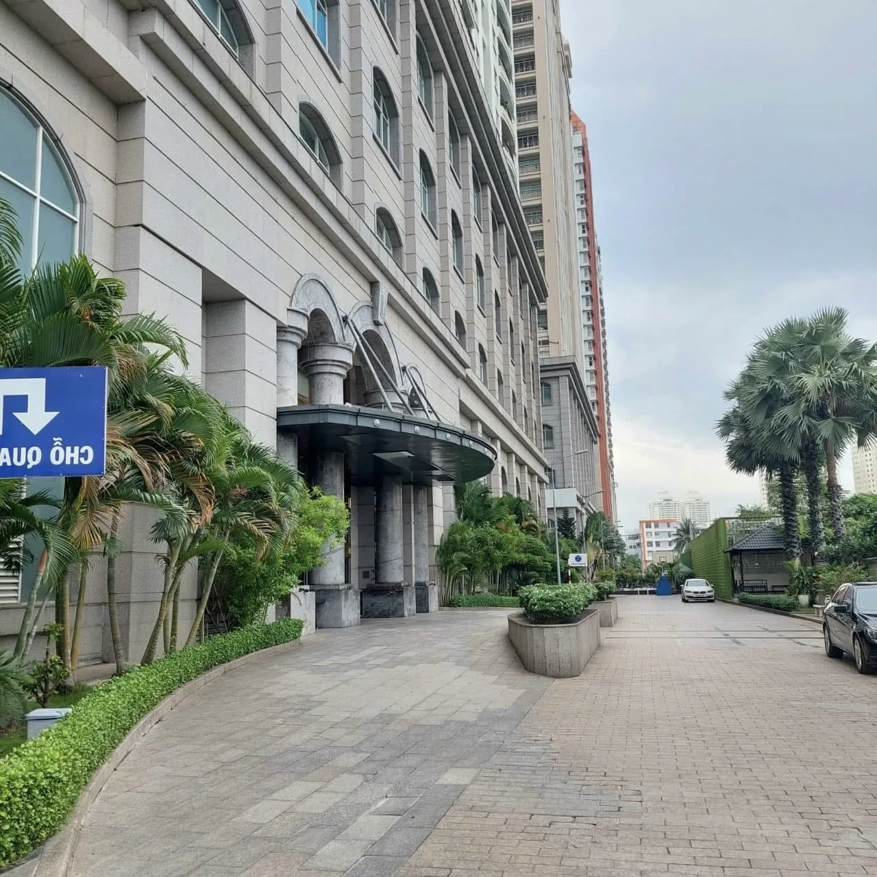 Lối đi lát gạch cạnh tòa nhà The Flemington với hàng cây xanh
