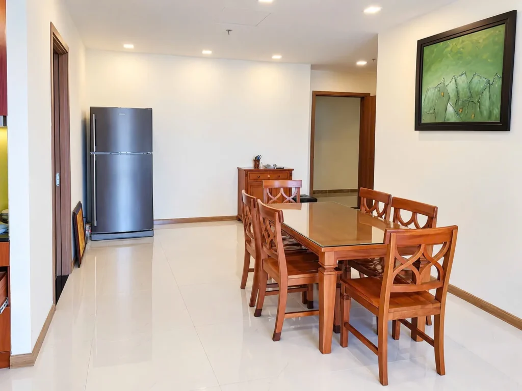 Bàn ăn gỗ sáu ghế cạnh tủ lạnh trong căn Vinhomes Central Park